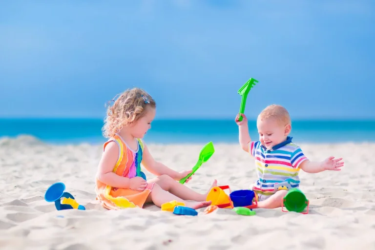 babies plays at beach with kids toys