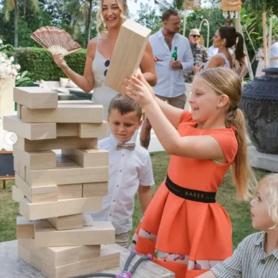 Family enjoying large indoor and outdoor games in a private villa, with kids and adults playing together in a spacious, tropical setting